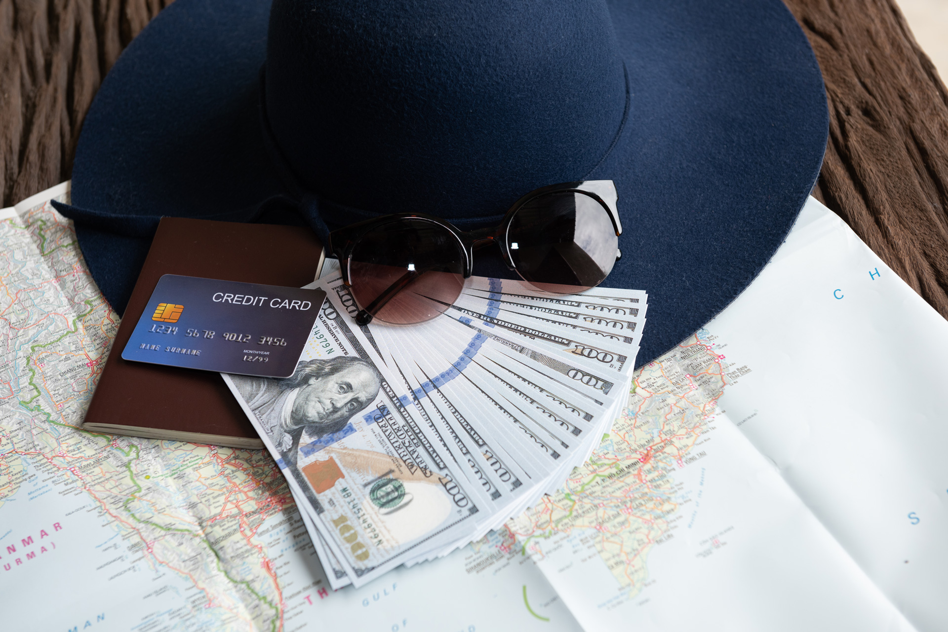 banconote-da-un-dollaro-occhiali-da-sole-carta-di-credito-passaporto-e-cappello-blu